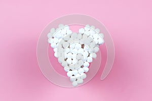 White cotton ear buds on a pink background