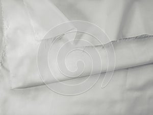 White cotton fabric with pleats and a tattered cutted edge