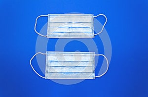 White cotton medical masks on a clasic  blue background