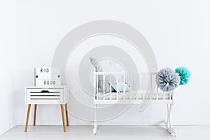 White cradle with pastel pompons photo