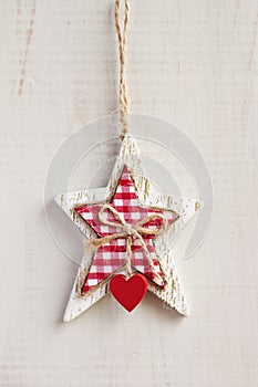 White craft star Christmas decoration hanging on white background vertical