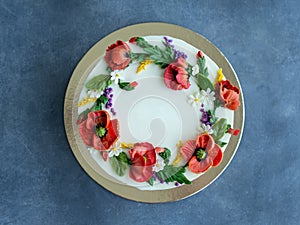 White cream cake decorated with buttercream flowers, Poppies, chamomile, cornflowers, spikelets of wheat, on gray background.