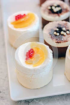 White cream cakes with fruits and berries in a restaraunt.