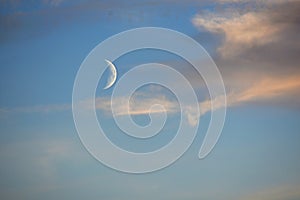 White crescent moon in blue sky
