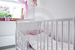 White crib in nursery room