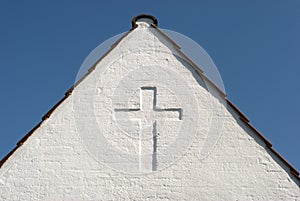 White cross on gable sky blue