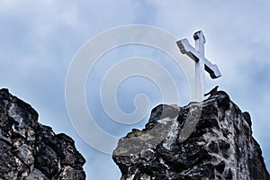 White cross on stone ruins with dramatic sky in Hermano Pedro, Antigua, Guatemala photo