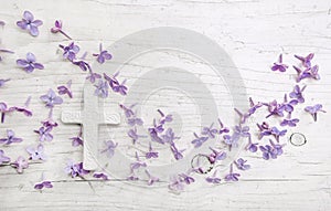 White cross and violet or purple lilac blossom on old background