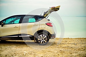 White crossover car on beach road. Travel, freedom concept. Digital detox. Summer vacation and holiday