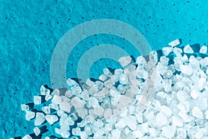 White crystals of coarse salt on blue background