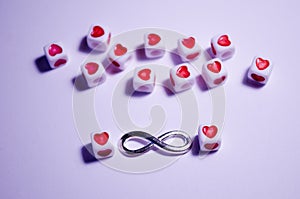White cubes beads with hearts on a white background. Sight of Infinity. Love and relationships. Incredible love. Symbolism of love