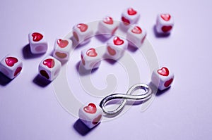 White cubes beads with hearts on a white background. Sight of Infinity. Love and relationships. Incredible love. Symbolism of love