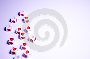 White cubes with red hearts. The 14th of February. White background and cubes side view. Dice beads. White background