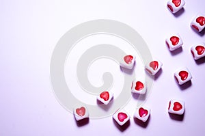 White cubes with red hearts. The 14th of February. White background and cubes side view. Dice beads. White background
