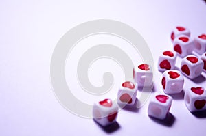 White cubes with red hearts. The 14th of February. White background and cubes side view. Dice beads. White background