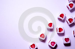 White cubes with red hearts. The 14th of February. White background and cubes side view. Dice beads. White background