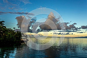 White Cumulostratus or Cumulus clouds over a lagoon on Samoa