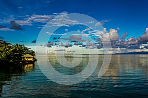 White Cumulostratus or Cumulus clouds over a lagoon in Samoa