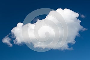 A white cumulus cloud against a dark blue daytime sky. A high resolution