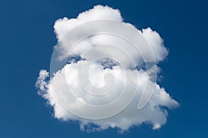 A white cumulus cloud against a dark blue daytime sky. A high resolution