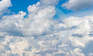 White cumulus clouds in the blue sky, illuminated by the bright spring sun.