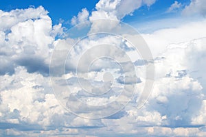 White cumulus clouds in the blue sky, illuminated by the bright spring sun.