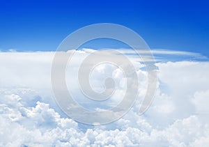White cumulus clouds on clear blue sky background, aerial cloudscape panoramic view from airplane, high azure skies panorama