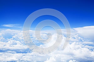 White cumulus clouds clear blue sky background, scenic aerial cloudscape view from airplane, high azure skies backdrop