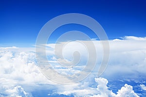 White cumulus clouds clear blue sky background, scenic aerial cloudscape view from airplane, high azure skies backdrop