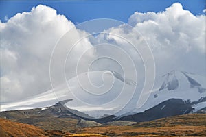 White Cumulus clouds come down from the mountains, autumn landsc