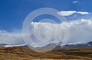 White Cumulus clouds come down from the mountains, autumn landsc