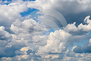 White Cumulus Clouds And Grey Storm Clouds On Blue Sky