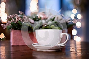 white cup on the background of christmas decorations and lights