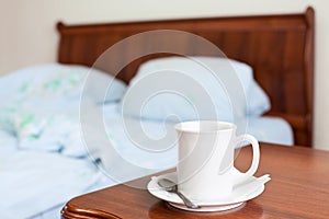 White cup on a bedside table