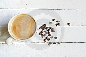 White cup of Black coffe with coffe beans and Copy Space on white wooden background