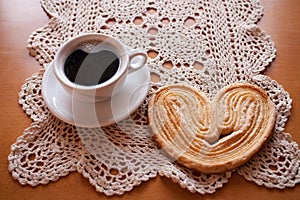white cup of black coffee and a sweet buttery cookie on the table