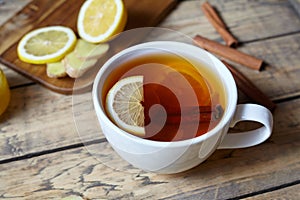 White cup of black natural tea with ginger, lemon and honey. Healthy Antiviral drink. Hot winter beverage concept.