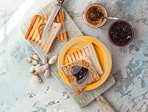 White cup of black tea with croissant or toasts with peanut butter, chokolate paste , jelly or jam on white wooden table, Breakfas