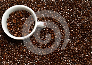 White cup of coffe in coffee beans. Separate coffee beans.