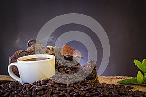 White cup and coffee beans and dark background