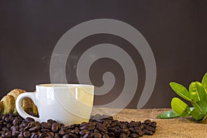 White cup and coffee beans and dark background