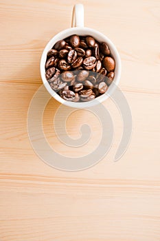 White cup of coffee beans with space for text