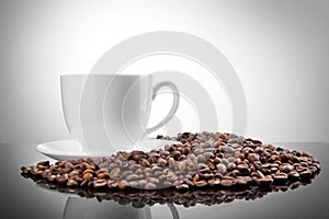 White cup with coffee beans on white