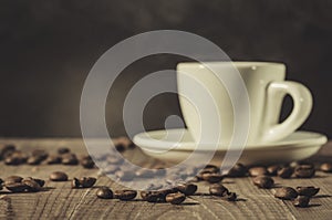 White cup of coffee and coffee beans on a dark wooden background/white cup of coffee and coffee beans on a dark wooden background