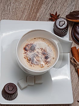 White cup with coffee. The cup stands on a white rectangular saucer.