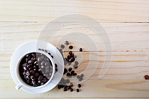 White cup with coffee grains on a wooden table-top.