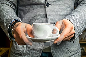 White cup of coffee in hands