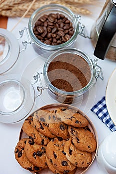 White cup of coffee and homemade round cookies with chocolate chips. Breakfast is on the table. Food at home. Still life. Coffee