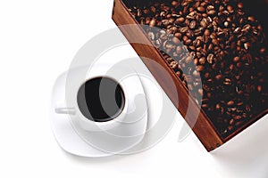 White cup of coffee on a white saucer, natural wooden box with coffee beans on a white background, isolate,  angle view from above
