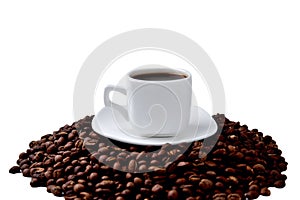 White cup of coffee on a white saucer stands on a hill of coffee beans on a white background , angle view from above